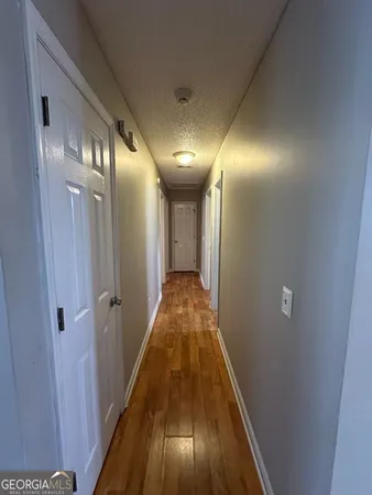 a view of a hallway with wooden floor