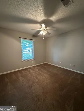 an empty room with windows and fan
