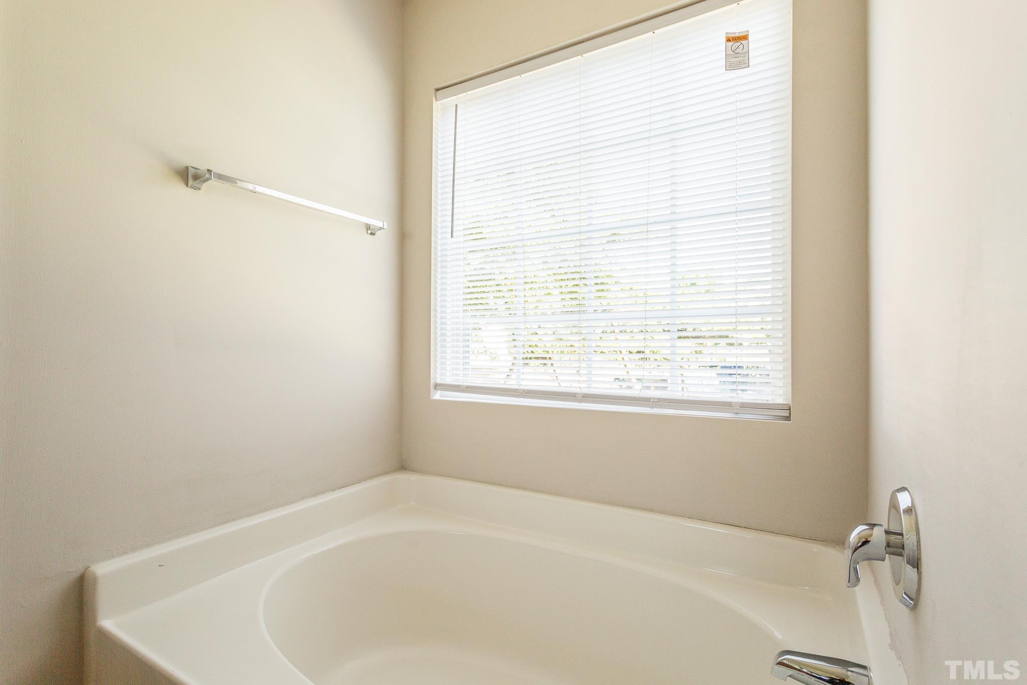 1004 Lombar Street Raleigh, NC 27610 - Photo 13 of 34 a white bath tub sitting in a bathroom next to a window