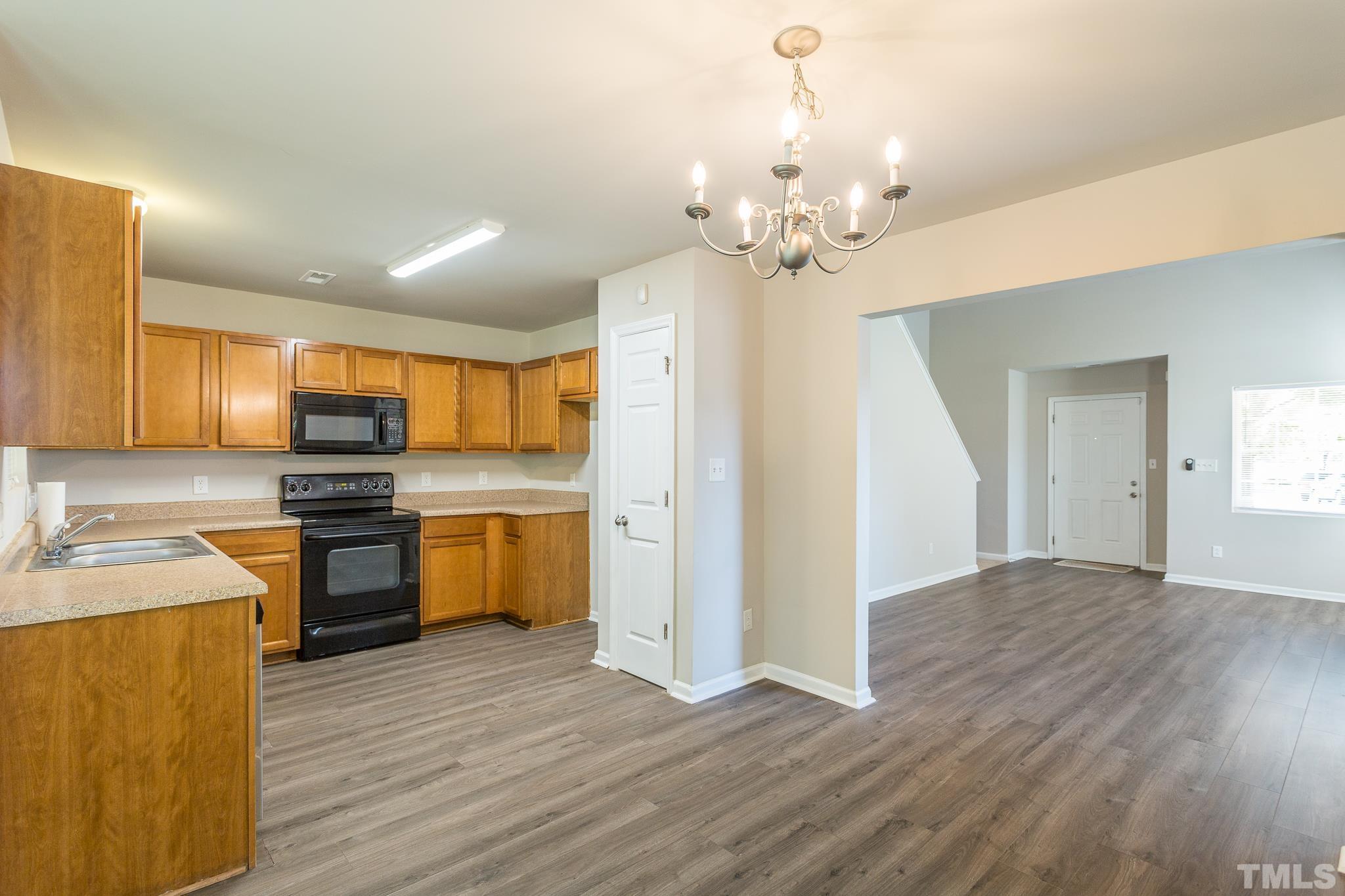 1004 Lombar Street Raleigh, NC 27610 - Photo 22 of 34 a view of a kitchen with a sink a kitchen island wooden floor and a refrigerator