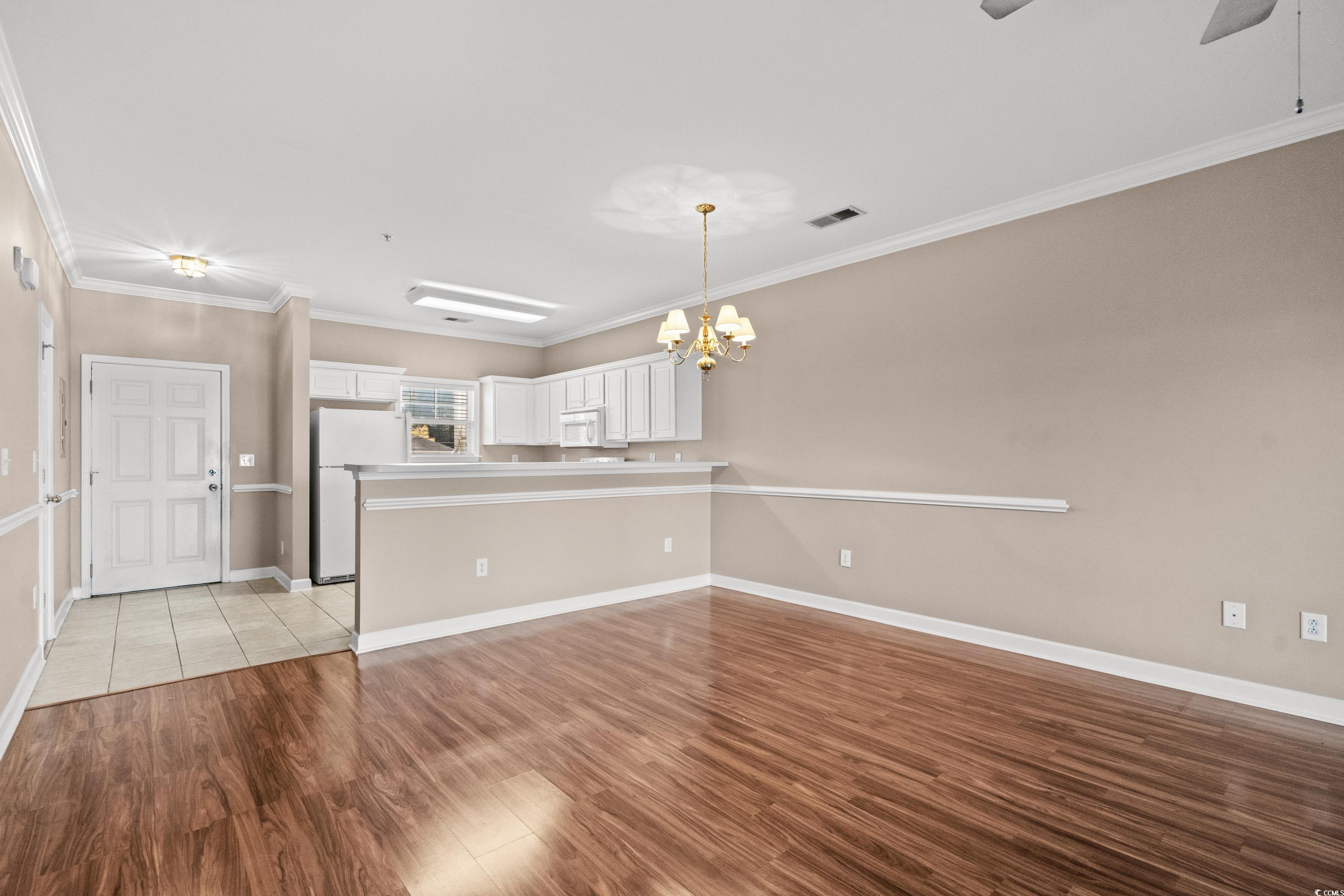 336 Kiskadee Loop, Unit B Conway, SC 29526 - Photo 12 of 40 Kitchen featuring light hardwood / wood-style floors, kitchen peninsula, ornamental molding, white cabinetry, and white appliances