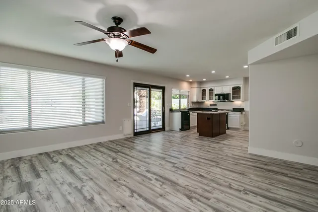 a view of an empty room with window and cabinet