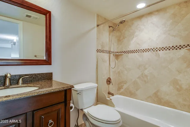 a bathroom with a granite countertop sink toilet and shower