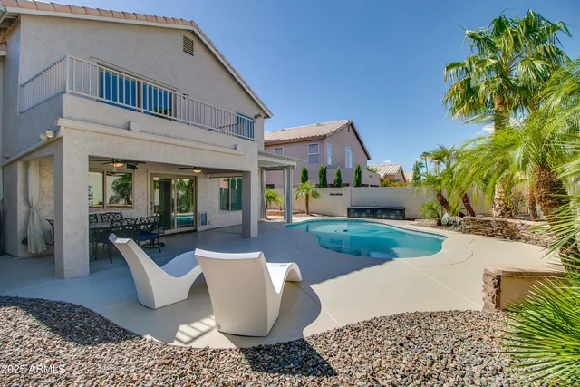 a view of a house with backyard and sitting area