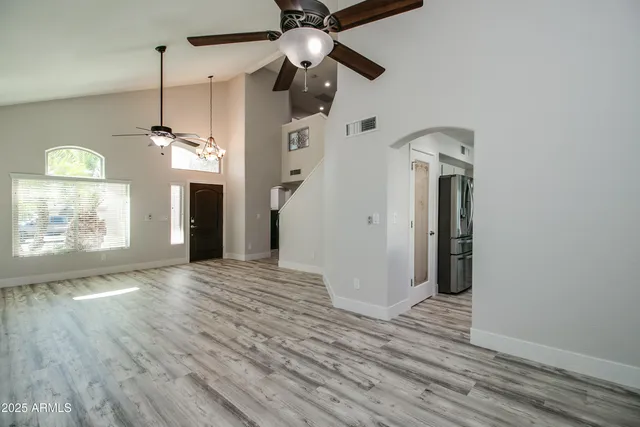 a view of a hallway with wooden floor and a chandelier