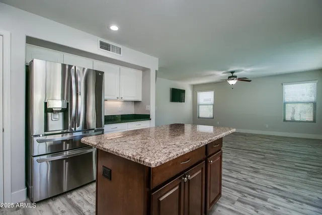 a kitchen with kitchen island stainless steel appliances a sink stove and refrigerator