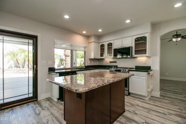 a kitchen with a center island appliances and cabinets