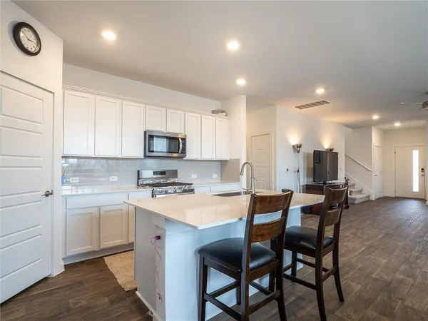 a kitchen with a table chairs microwave and cabinets