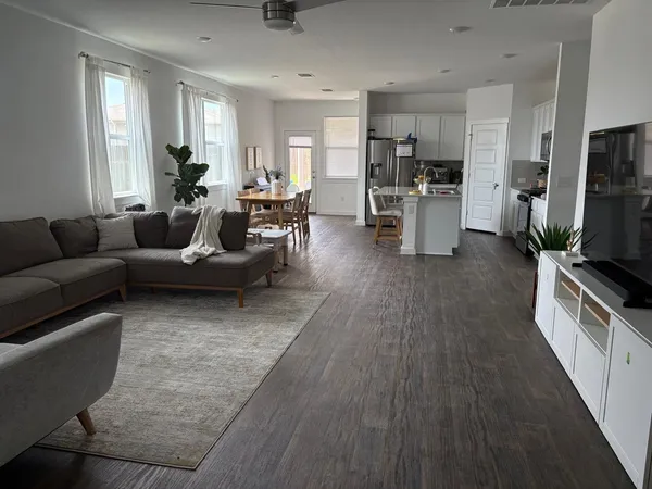 a kitchen with stainless steel appliances granite countertop a stove a refrigerator a kitchen island with chairs and wooden floor