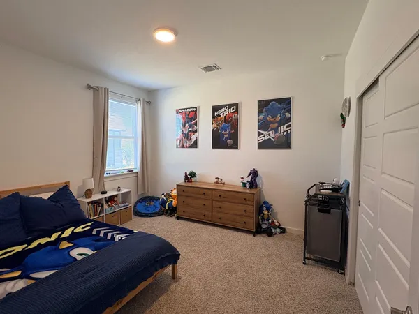 a bedroom with a bed a couch and a flat screen tv
