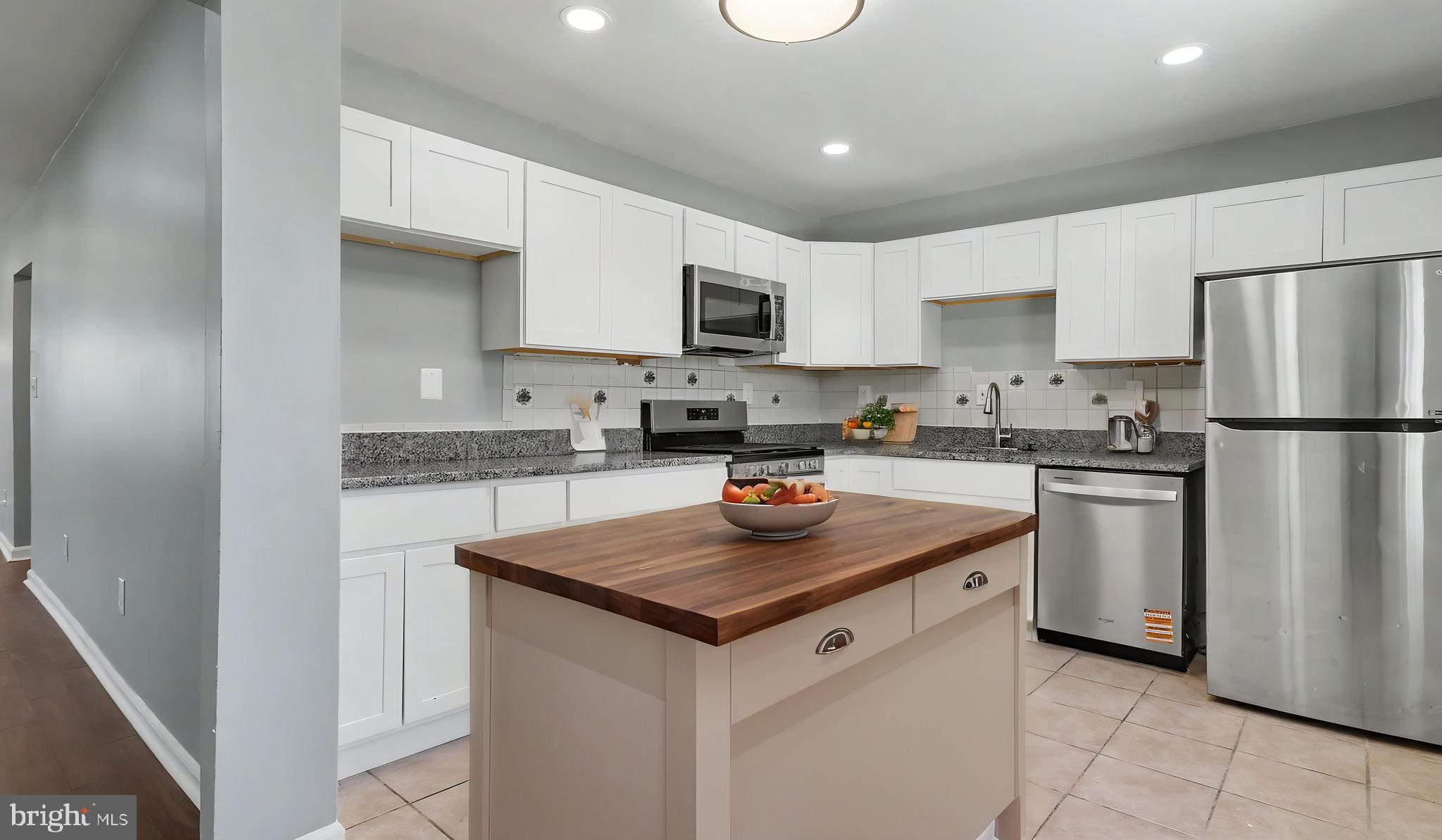 4203 Shell Street Capitol Heights, MD 20743 - Photo 40 of 47 a kitchen with stainless steel appliances granite countertop a refrigerator a sink a stove a microwave and white cabinets