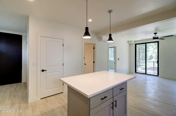 a kitchen with a refrigerator a sink and wooden floor