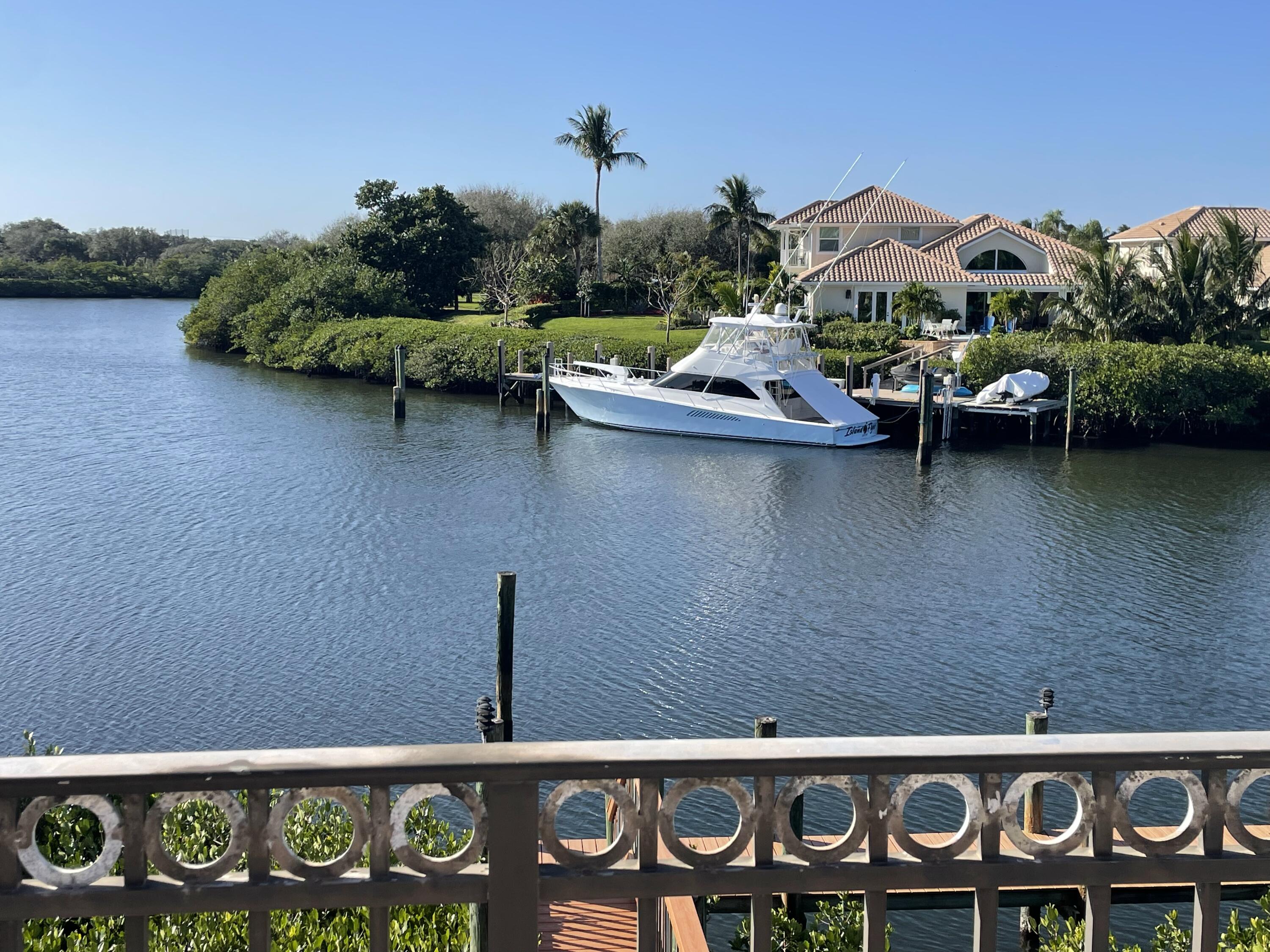 an ocean view with boat and palm trees