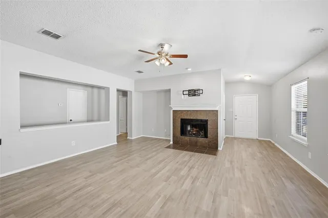 a view of empty room with wooden floor and fireplace