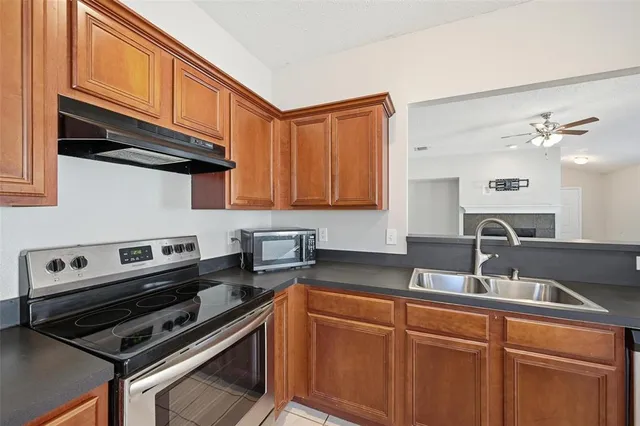 a kitchen with stainless steel appliances granite countertop a sink stove and cabinets