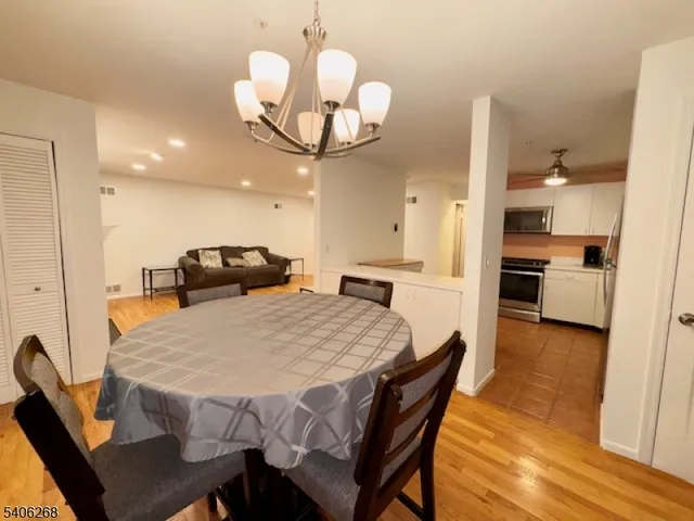 a kitchen with a dining table chairs and chandelier