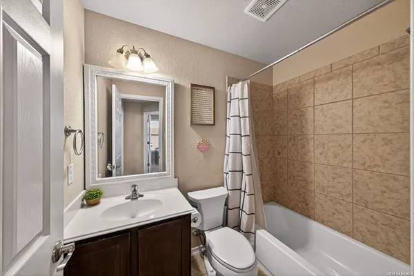 a bathroom with a sink a toilet a mirror and shower