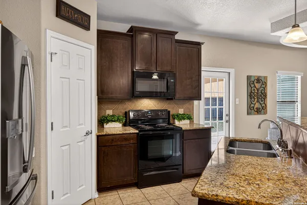 a kitchen with stainless steel appliances granite countertop a stove a sink and a refrigerator