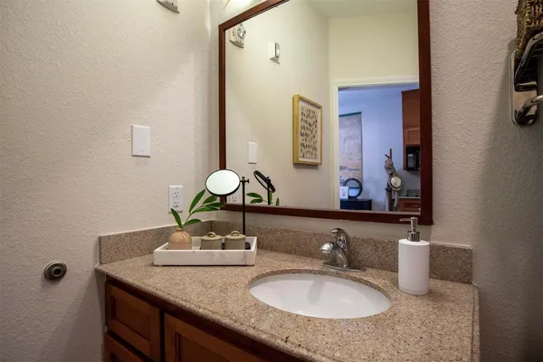 a bathroom with a granite countertop sink and a mirror