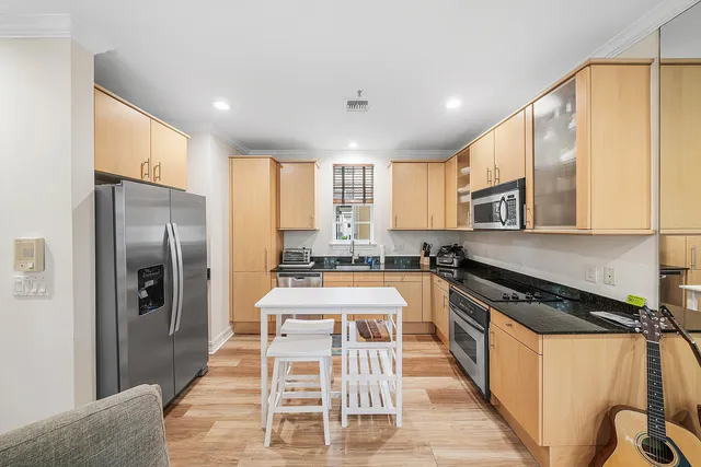 a kitchen with stainless steel appliances granite countertop a stove a sink and a refrigerator