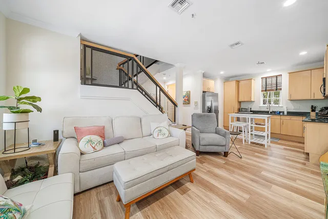 a living room with furniture and a view of kitchen