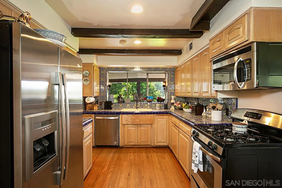 1465 Rodeo Drive La Jolla, CA 92037 - Photo 13 of 24 a kitchen with stainless steel appliances sink a microwave and cabinets