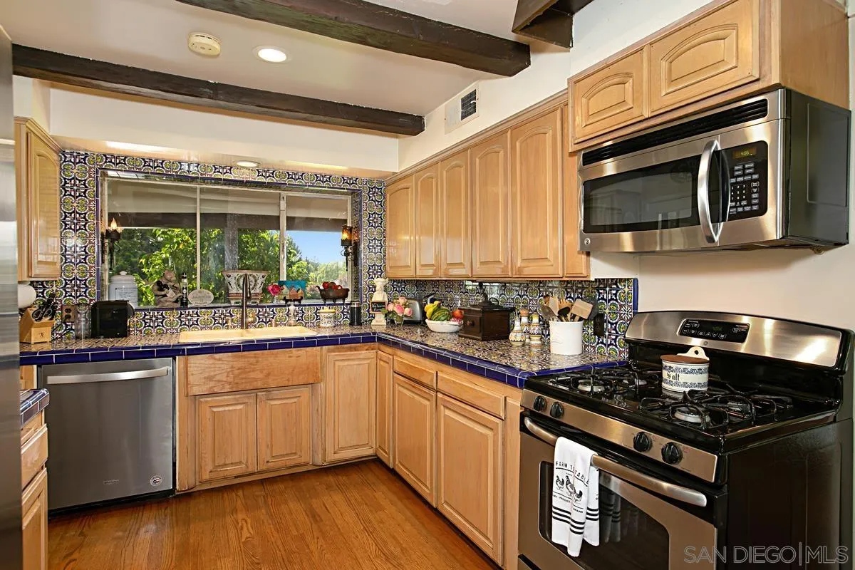 1465 Rodeo Drive La Jolla, CA 92037 - Photo 14 of 24 a kitchen with stainless steel appliances a sink a stove and cabinets