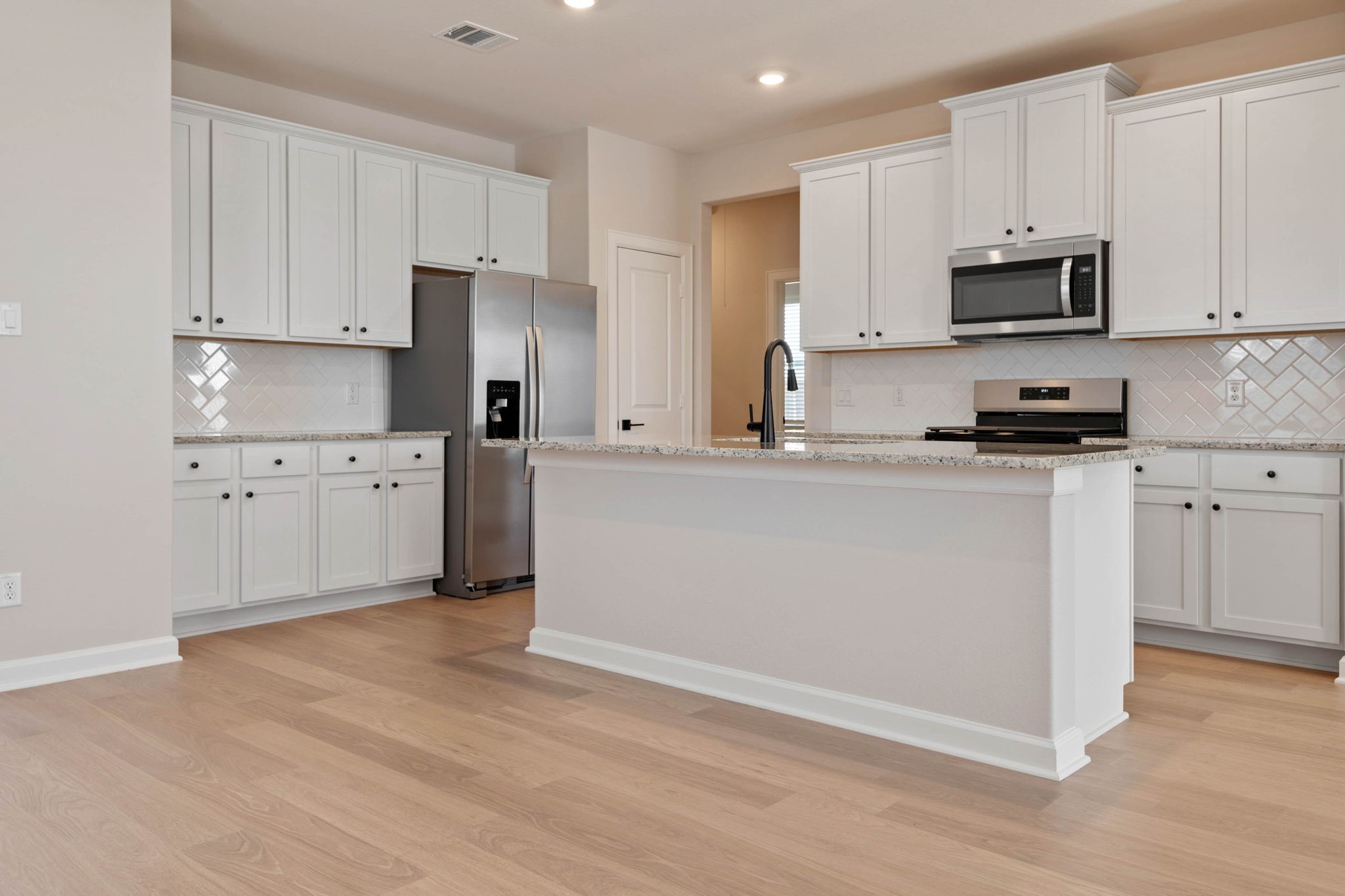 1115 Moonlight Trce Drive Beasley, TX 77417 - Photo 6 of 14 a kitchen with granite countertop white cabinets and stainless steel appliances