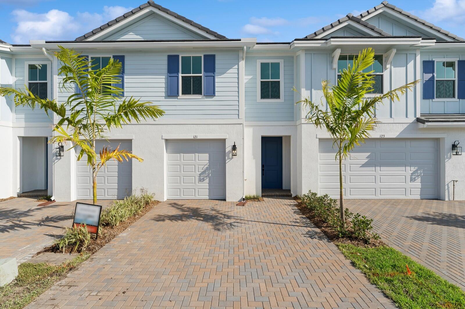121 Southeast Birch Terrace, Unit 1157 Stuart, FL 34997 - Photo 1 of 34 a front view of a house with a yard