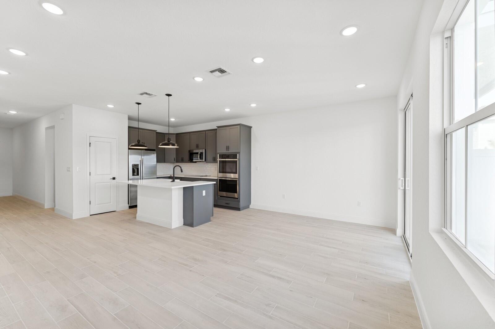 121 Southeast Birch Terrace, Unit 1157 Stuart, FL 34997 - Photo 12 of 34 a large kitchen with stainless steel appliances kitchen island a large counter top and a sink