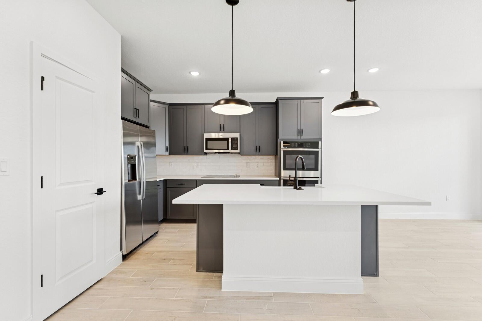 121 Southeast Birch Terrace, Unit 1157 Stuart, FL 34997 - Photo 7 of 34 a kitchen with kitchen island a counter top space a sink and appliances