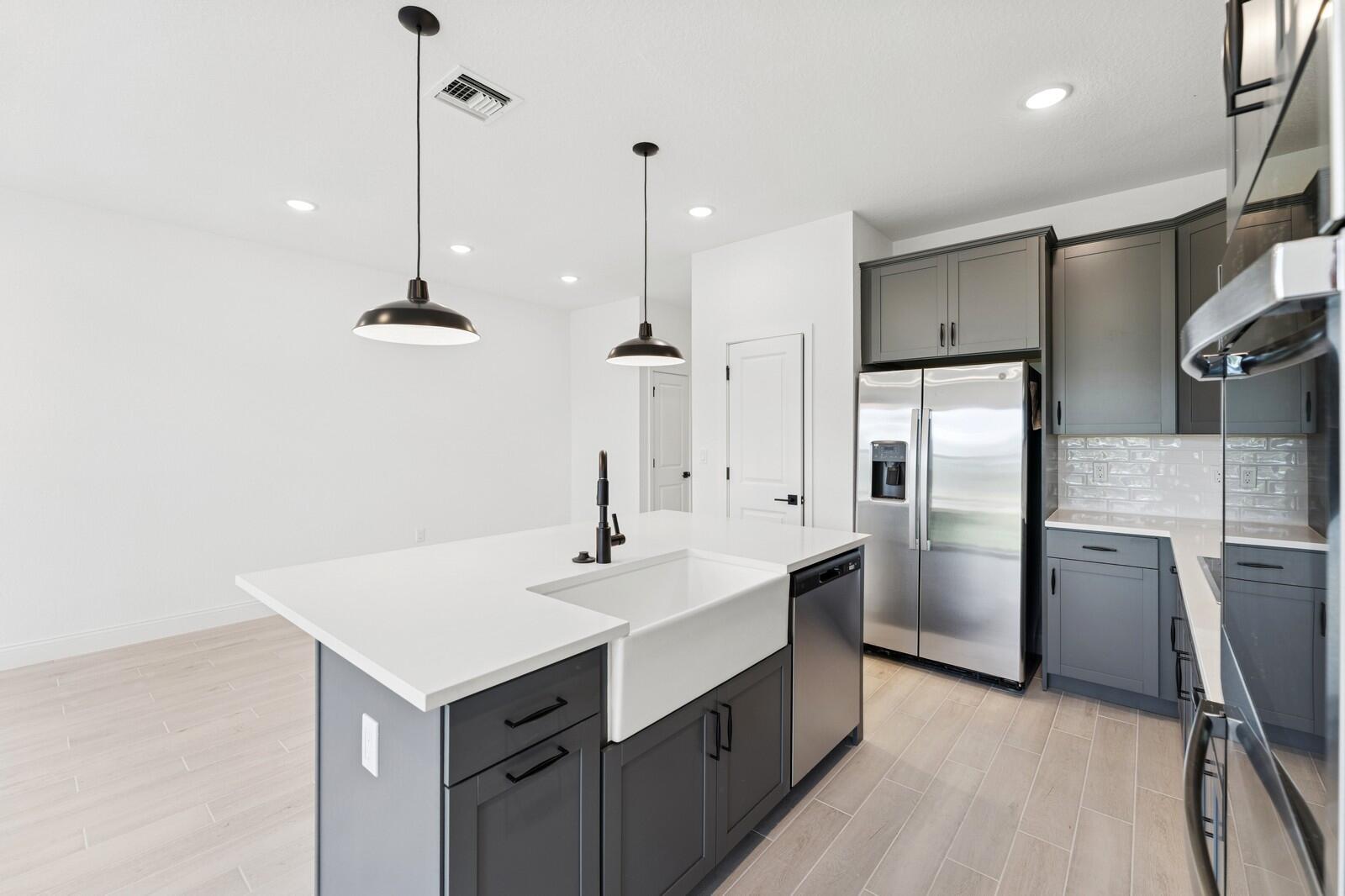 121 Southeast Birch Terrace, Unit 1157 Stuart, FL 34997 - Photo 10 of 34 a kitchen with refrigerator cabinets and wooden floor