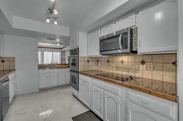 a kitchen with stainless steel appliances granite countertop a sink and stove top oven