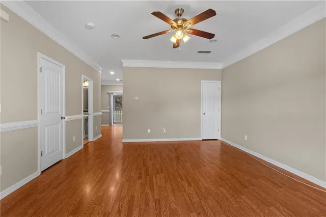 a view of a big room with wooden floor and a kitchen