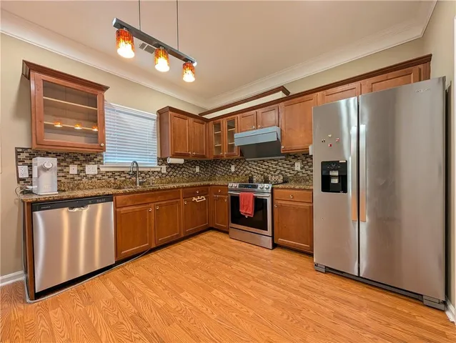 a kitchen with stainless steel appliances a refrigerator sink and cabinets