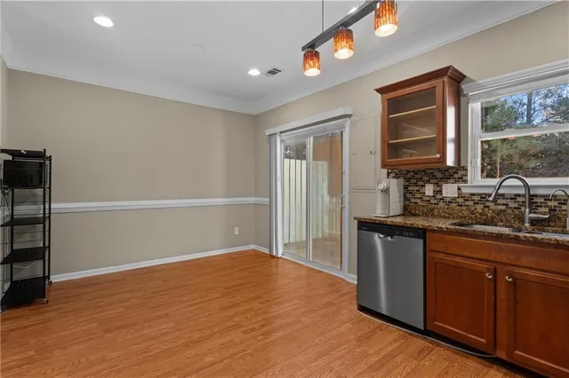 a kitchen with granite countertop a sink cabinets and wooden floor