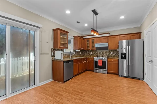 a kitchen with stainless steel appliances granite countertop a refrigerator and a sink