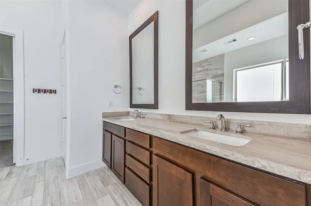 a bathroom with a double vanity sink and a mirror