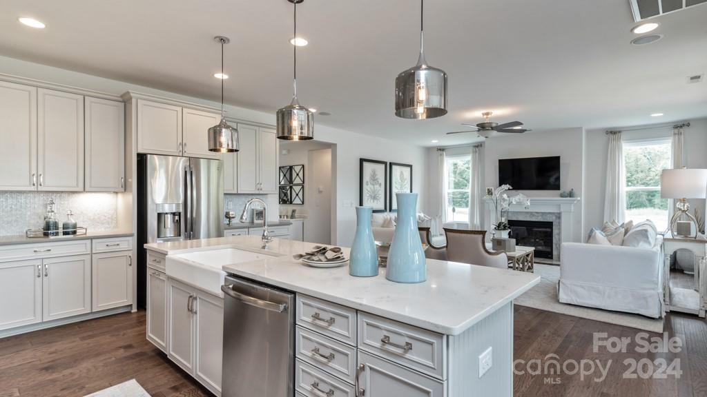 1237 Sugar Crk Road Indian Land, SC 29707 - Photo 8 of 25 a kitchen with stainless steel appliances kitchen island granite countertop a refrigerator a stove a sink a dining table and chairs with wooden floor