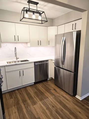 a kitchen with stainless steel appliances a refrigerator sink and cabinets