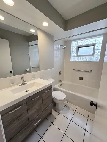 a bathroom with a double vanity sink a toilet and a bathtub