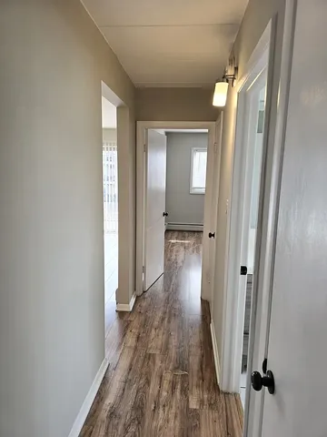 a view of a hallway with wooden floor and staircase