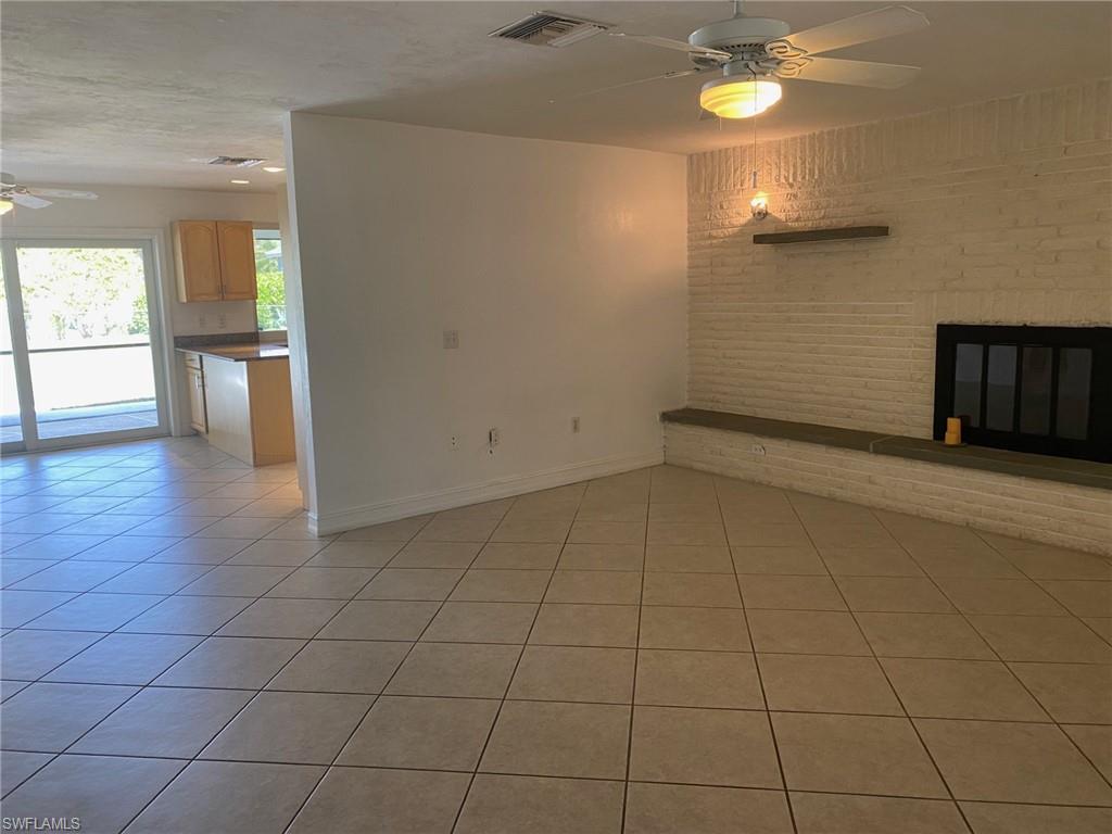 5241 Cypress Lane Naples, FL 34113 - Photo 3 of 15 an empty room with wooden floor and windows