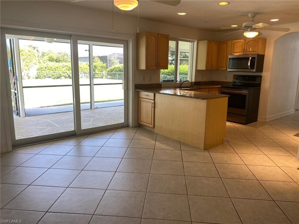 5241 Cypress Lane Naples, FL 34113 - Photo 4 of 15 a kitchen with a sink a counter top space cabinets and stainless steel appliances