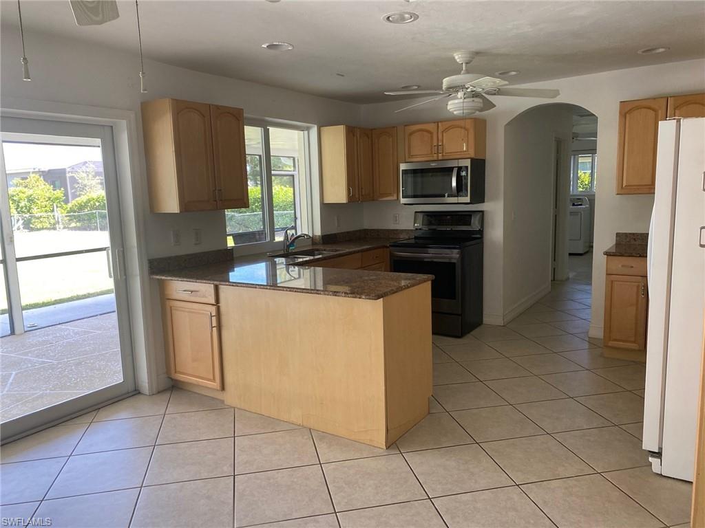 5241 Cypress Lane Naples, FL 34113 - Photo 5 of 15 a kitchen with stainless steel appliances granite countertop a refrigerator and a stove