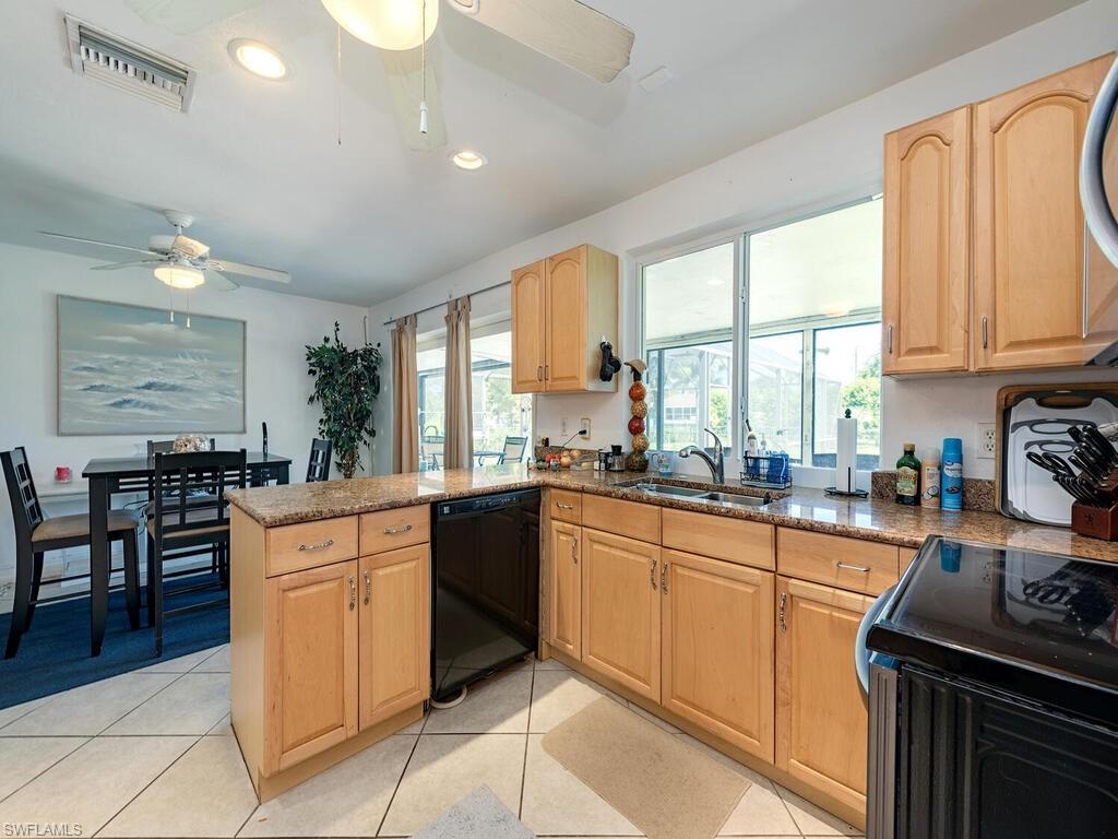5241 Cypress Lane Naples, FL 34113 - Photo 6 of 15 a kitchen with stainless steel appliances granite countertop sink stove top oven and cabinets