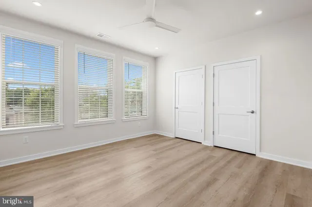 an empty room with wooden floor and windows