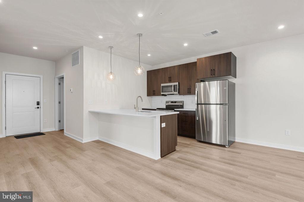 26 South York Road, Unit 210 Hatboro, PA 19040 - Photo 13 of 51 a kitchen with refrigerator a microwave and white cabinets