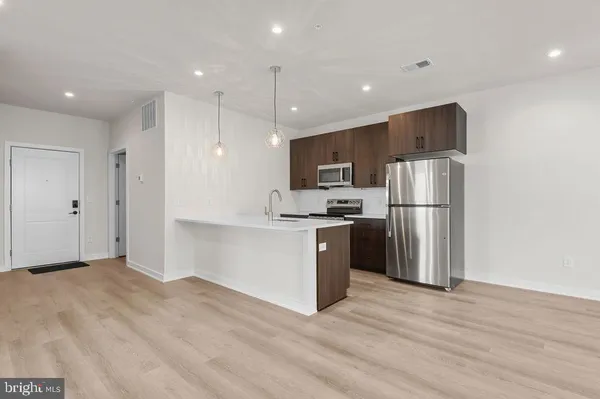 a kitchen with a sink a window and wooden floor
