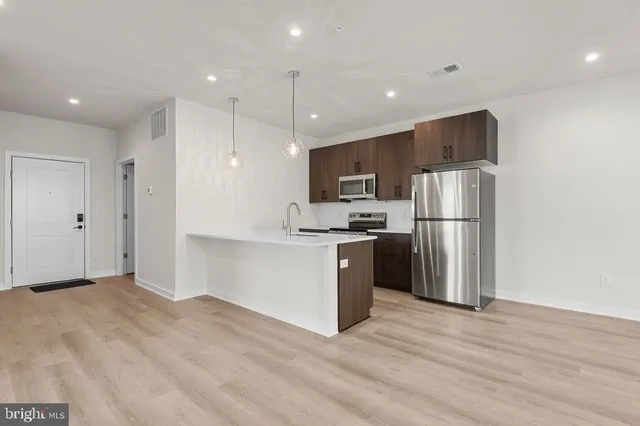 a kitchen with a sink a window and wooden floor